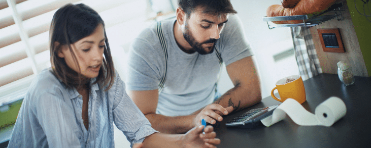 white woman and white man typing on calculator