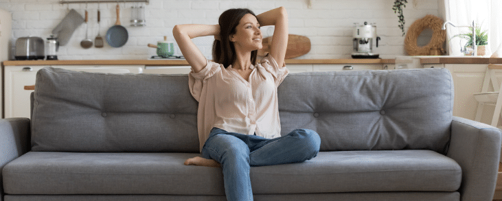 white woman sitting on couch looking happy