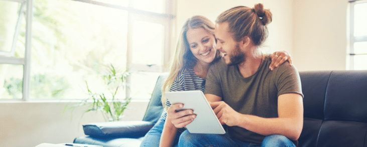 white man and woman happy looking at tablet