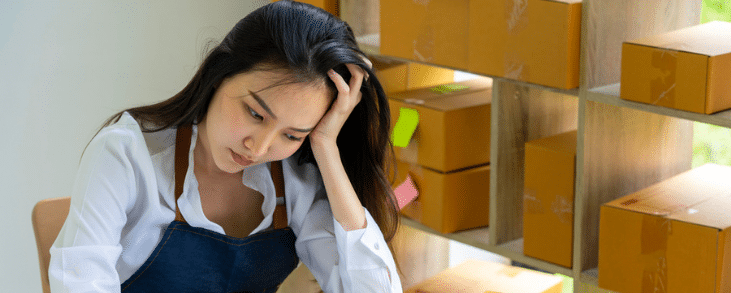 asian woman with head in hand looking frustrated