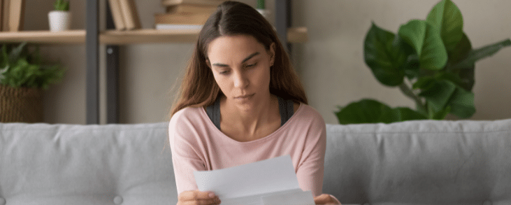 woman reading letter on couch