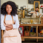 black woman with apron standing in storefront