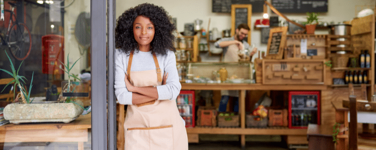 black woman with apron standing in storefront