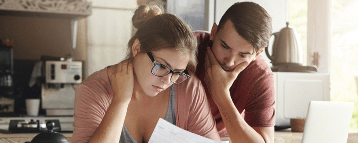 white couple looking at document concerned