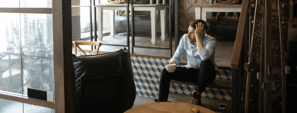 male business owner looks upset that business is closing